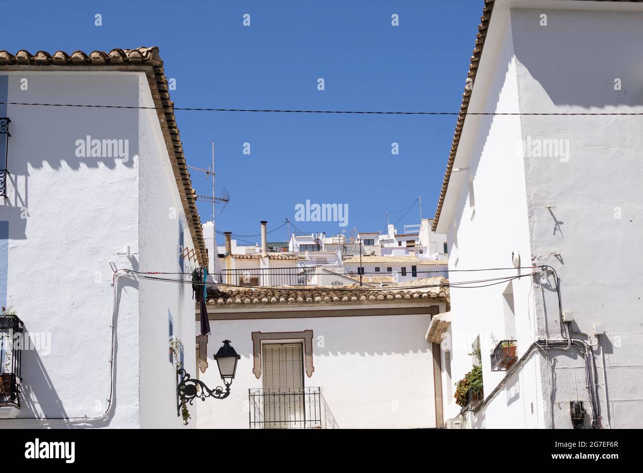 Bâtiments résidentiels typiquement méditerranéens blanchis à la chaux et tuiles de toit en terre cuite à Altea, Alicante Espagne sous ciel bleu. Banque D'Images