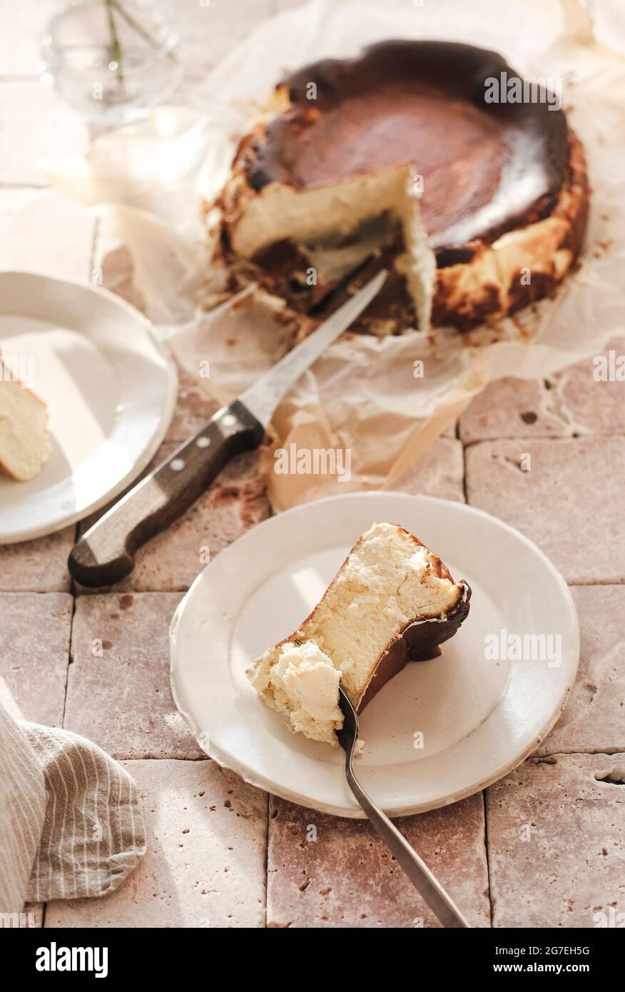 Morceau de San Sebastian maison a brûlé cheesecake sur plaque blanche, vue de dessus, foyer sélectif. Concept de desserts artisanaux faits maison Banque D'Images