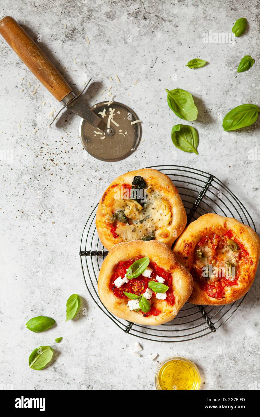 Mini pizzas - pizzeria - nappées de fromage et de tomates, de jambon italien et de piment Banque D'Images