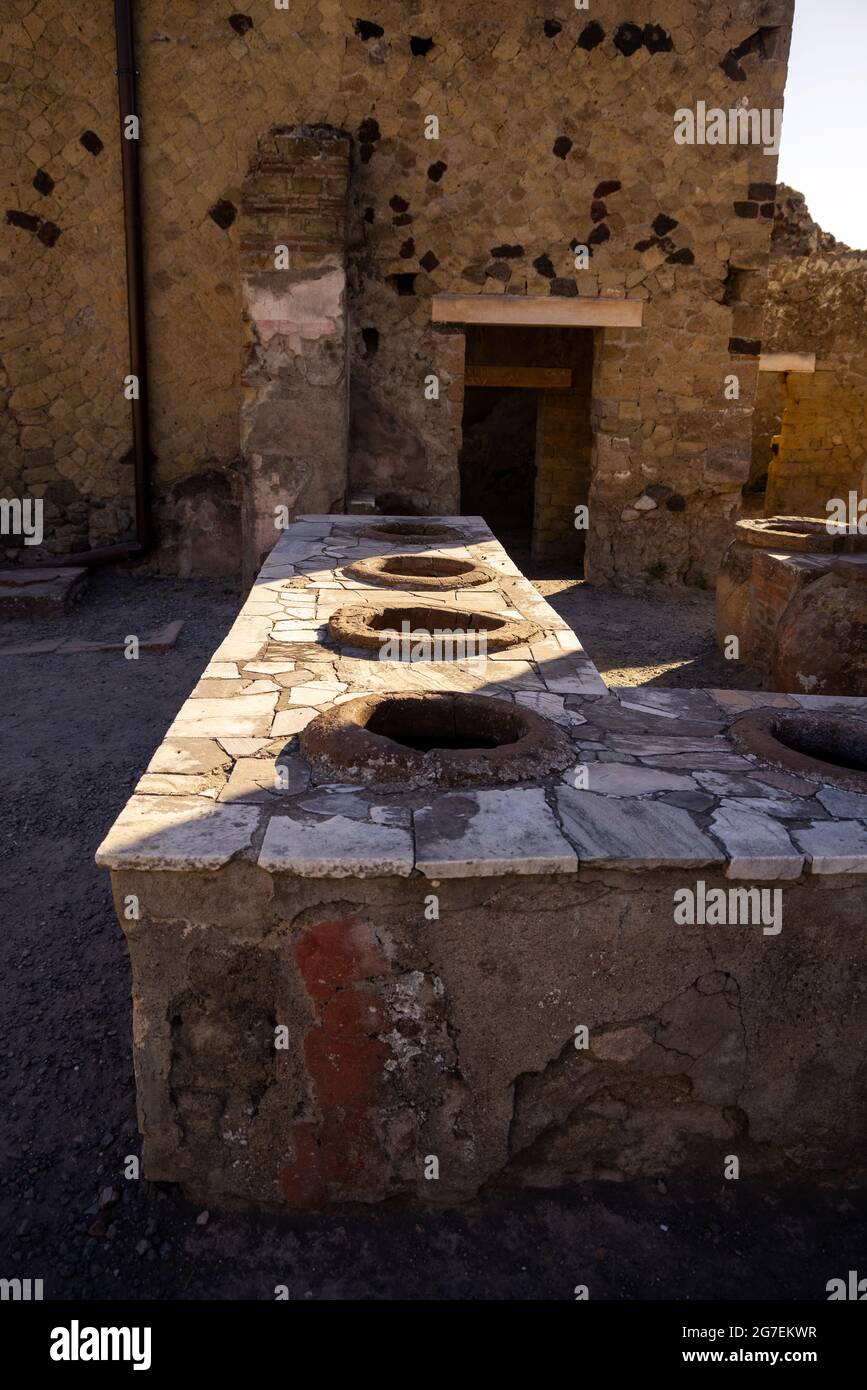 Thermopolis ou Taberna (magasin de cuisine) à Ercolano - Herculanum, ancienne ville romaine détruite par l'éruption du Vésuve ou Vésuve volcan. Banque D'Images