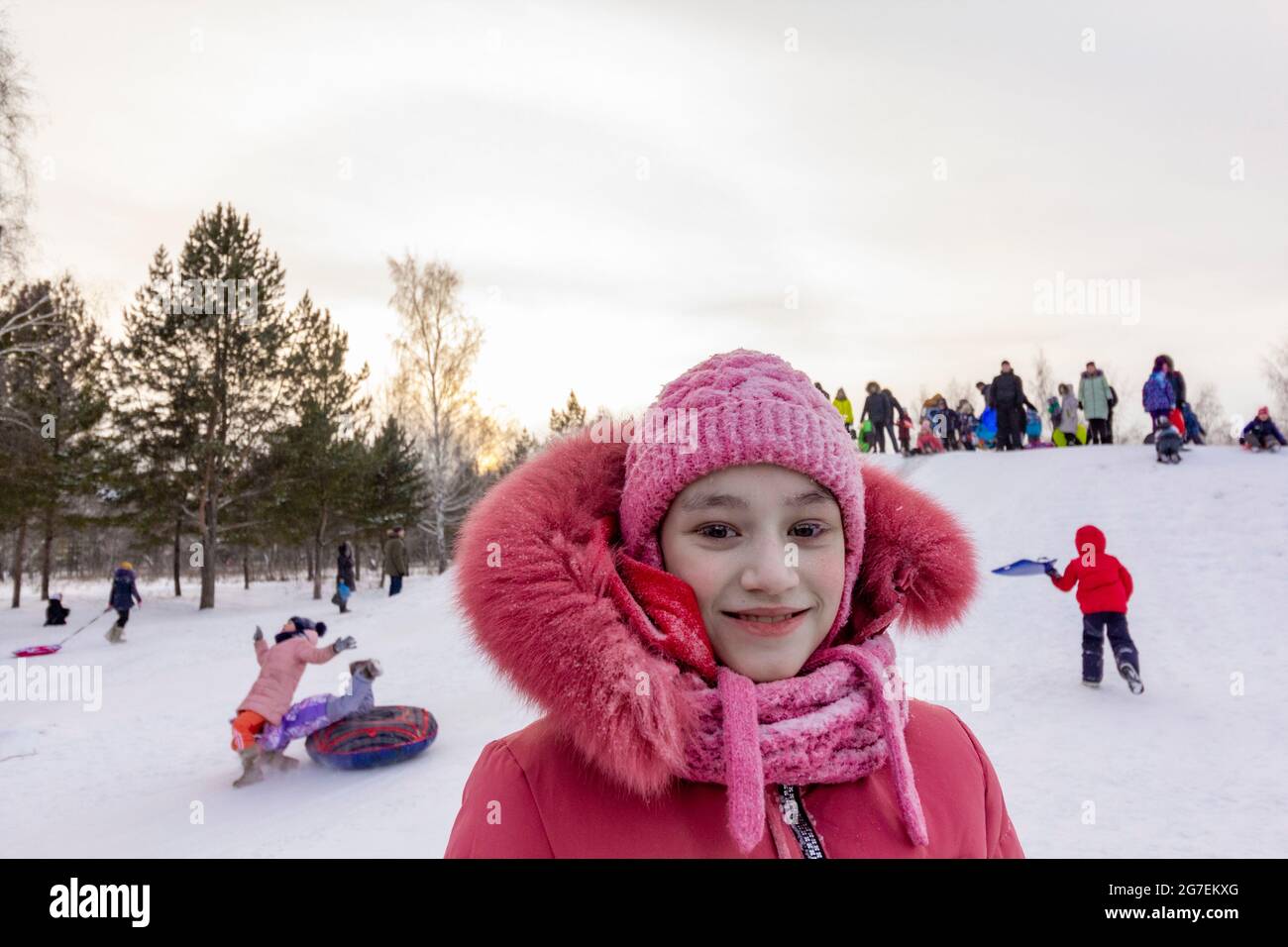 Fille avec du gel sur les cils sur le fond de jouer des enfants dans le plus froid dans le village résidentiel du nord du monde Oymyakon. Banque D'Images