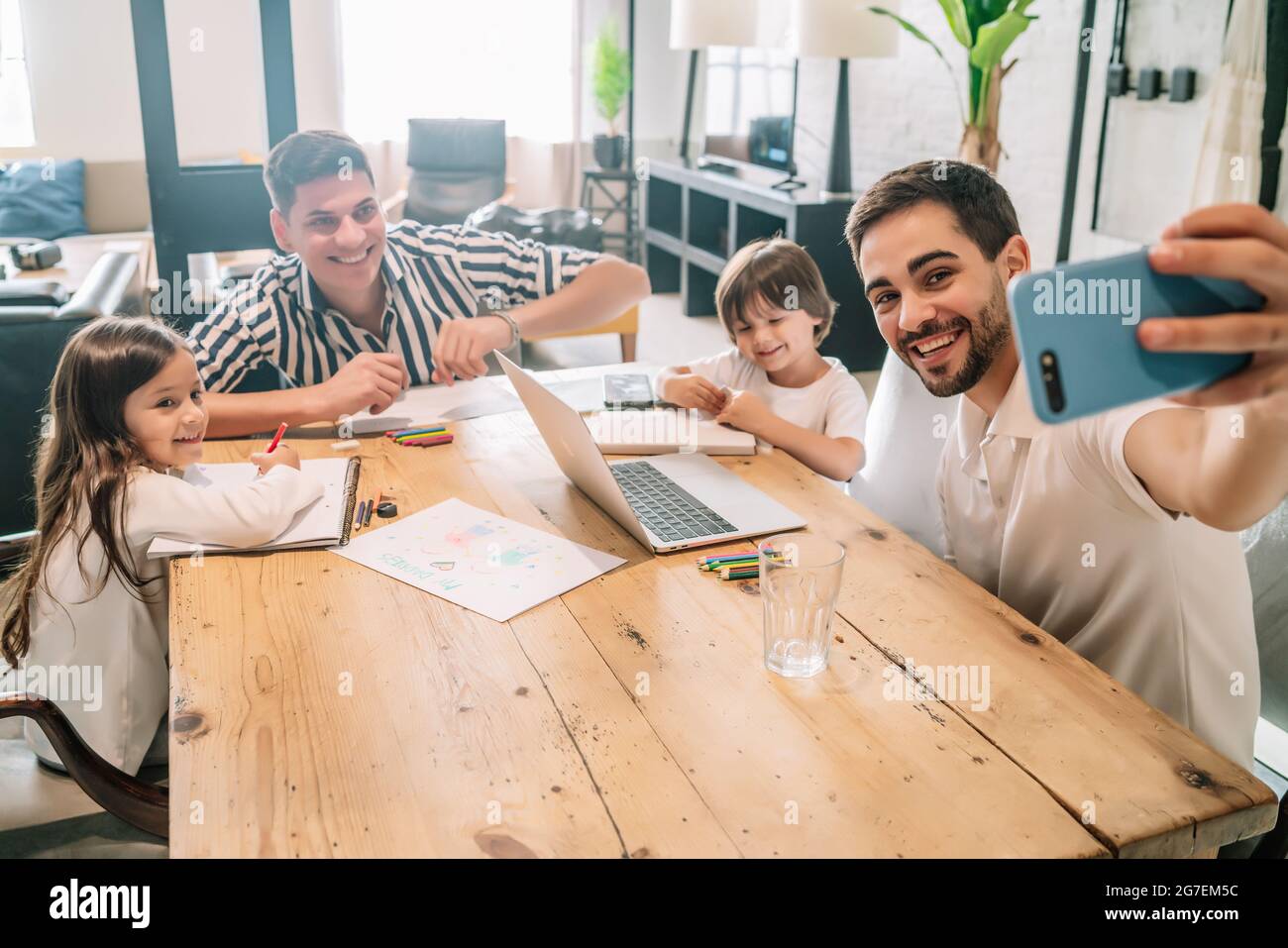 Couple gay prenant un selfie avec leur fille et leur fils à la maison. Banque D'Images