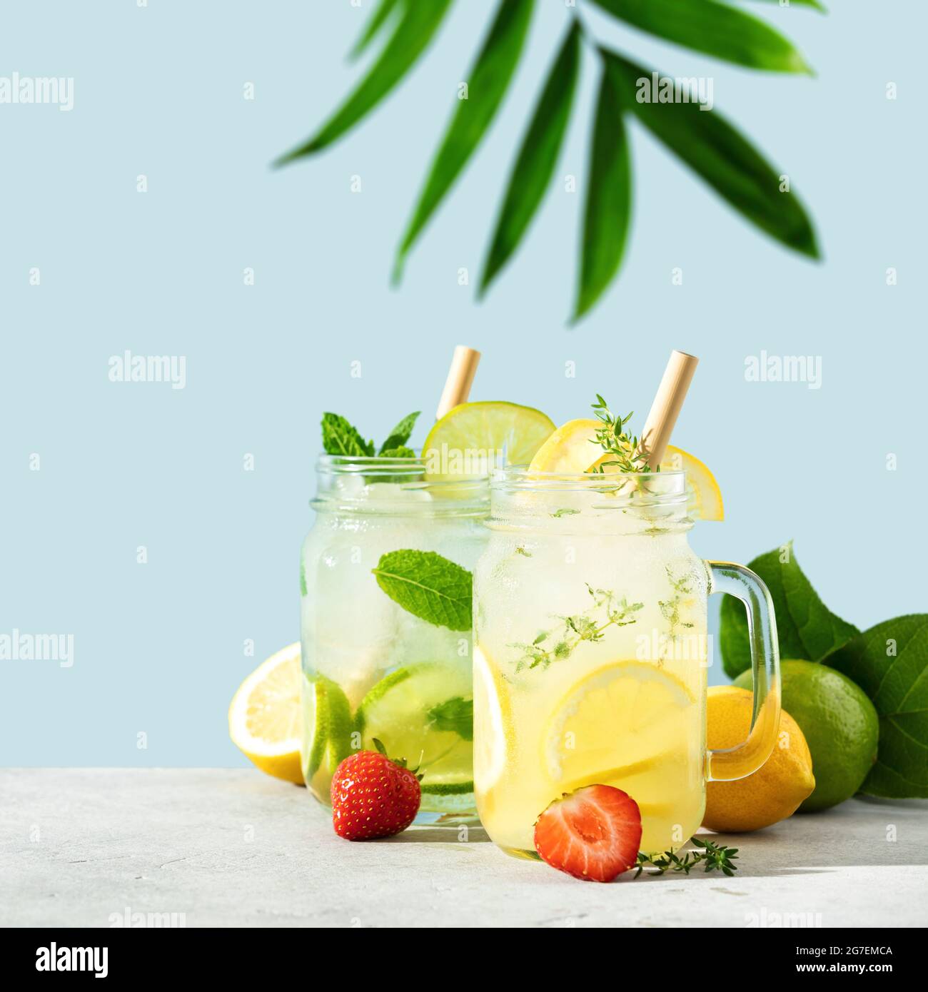 Limonade et mojito sur fond bleu ciel. Cocktails maison rafraîchissants, boissons estivales, sélection. Ombres ensoleillées Banque D'Images