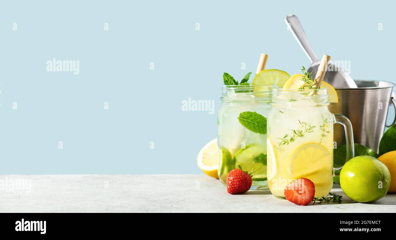 Limonade et mojito sur fond bleu ciel. Cocktails maison rafraîchissants, boissons estivales, sélection. Ombres de jour ensoleillées, espace de copie Banque D'Images