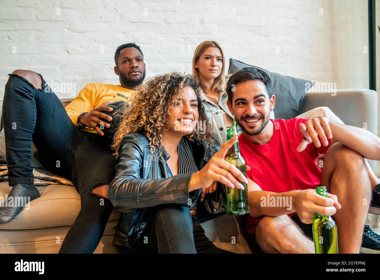 Amis qui ont du bon temps en regardant un match ensemble. Banque D'Images