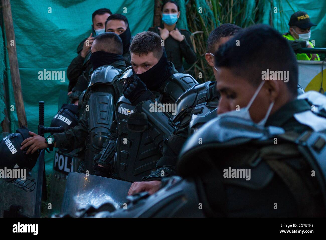 Les policiers anti-émeutes de Colombie sont équipés de boucliers pour empêcher les femmes de ménage d'atteindre les ouvriers du bâtiment dans une zone de construction dangereuse, les services à l'enfance de Colombie (ICBF) et la police anti-émeute (ESMAD) expulsent des familles qui vivent dans un quartier à faible revenu et qui s'effondre en raison du terrain à Itagui, Antioquia - Colombie. 12 juillet 2021 Banque D'Images