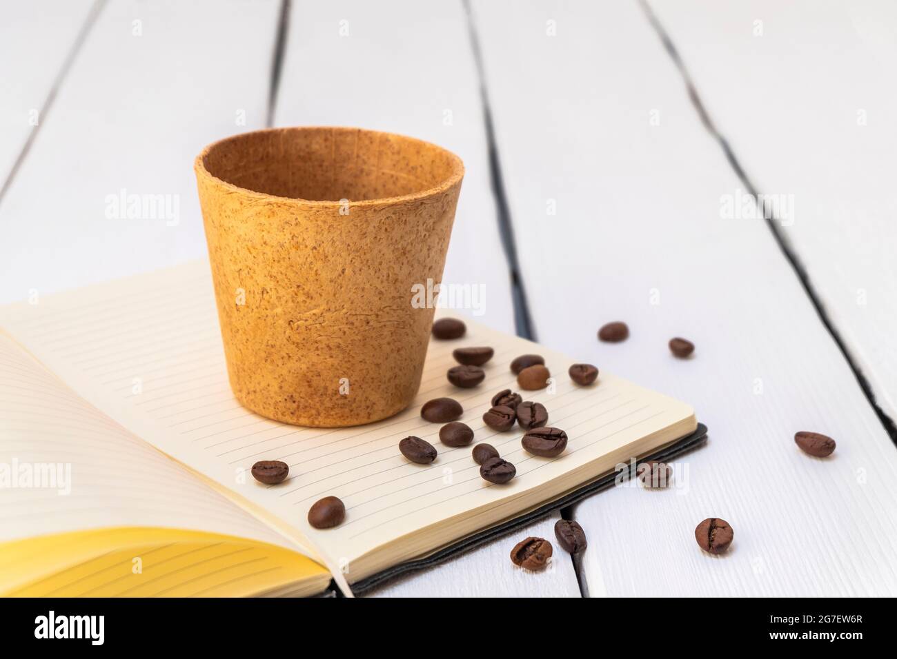 Tasse à café comestible avec haricots rôtis sur fond blanc. Image de style de vie, concept zéro déchet Banque D'Images