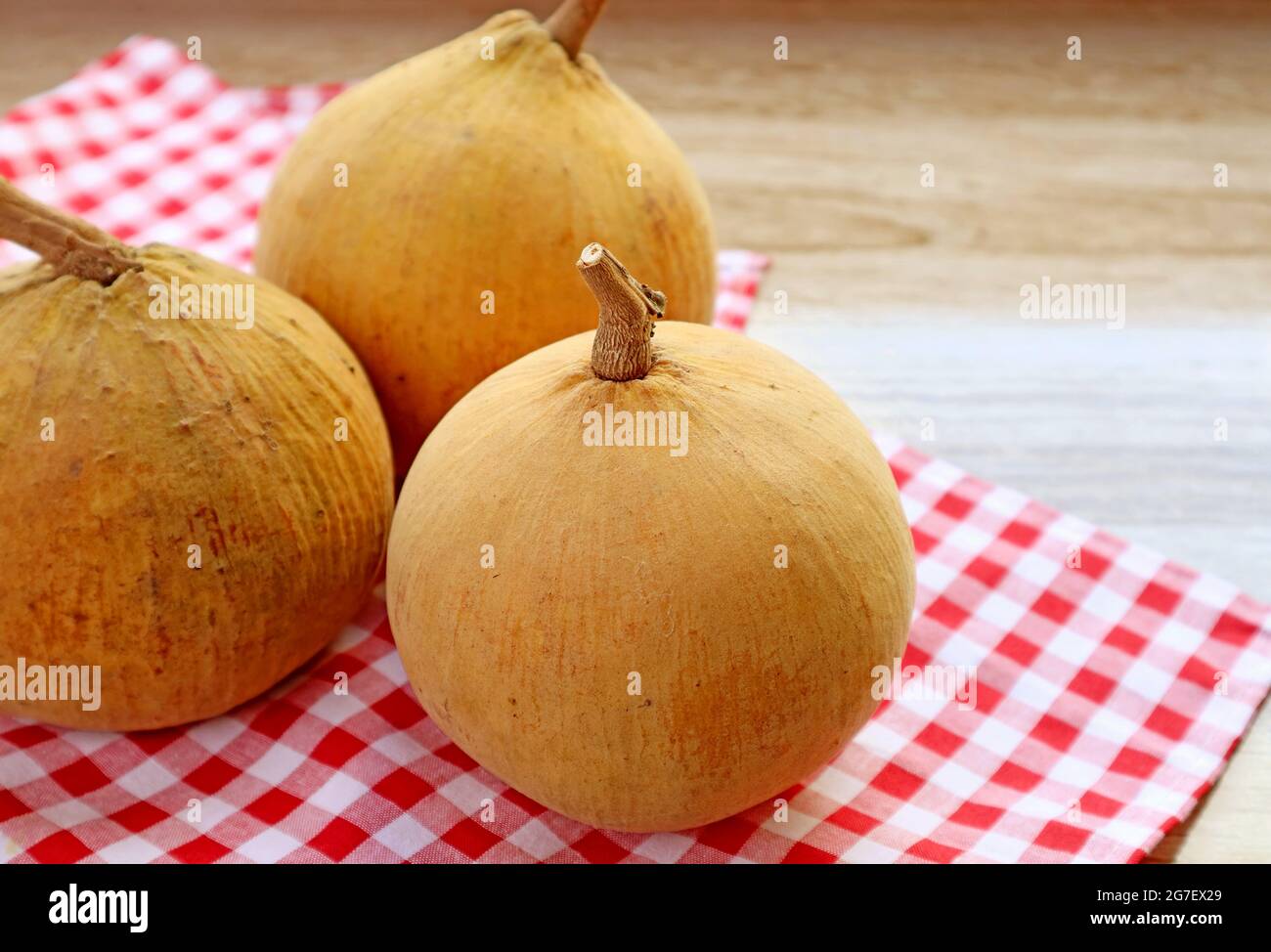 Gros plan tas de fruits de coton mûr frais ou Santol sur le tissu rouge Checkers Banque D'Images