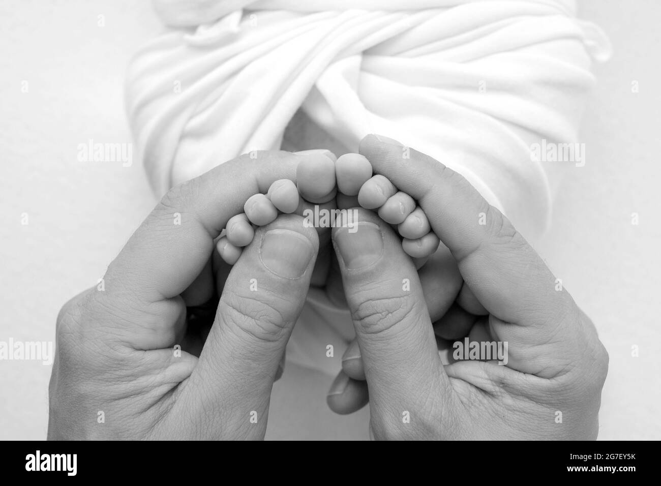 Les Mains Des Parents Les Jambes Du Nouveau Ne Dans Les Mains De La Mere Et Du Pere Les Pieds Du Bebe Dans Les Mains Noir Et Blanc Photo Stock Alamy