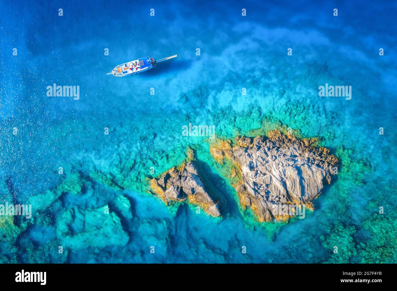 Vue aérienne du magnifique yacht sur la mer et des rochers au coucher du soleil Banque D'Images
