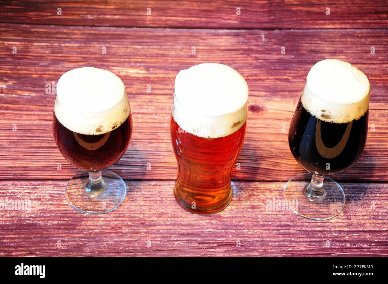Trois verres avec différents types de bière foncée sont sur une table en bois. Gros plan. Banque D'Images