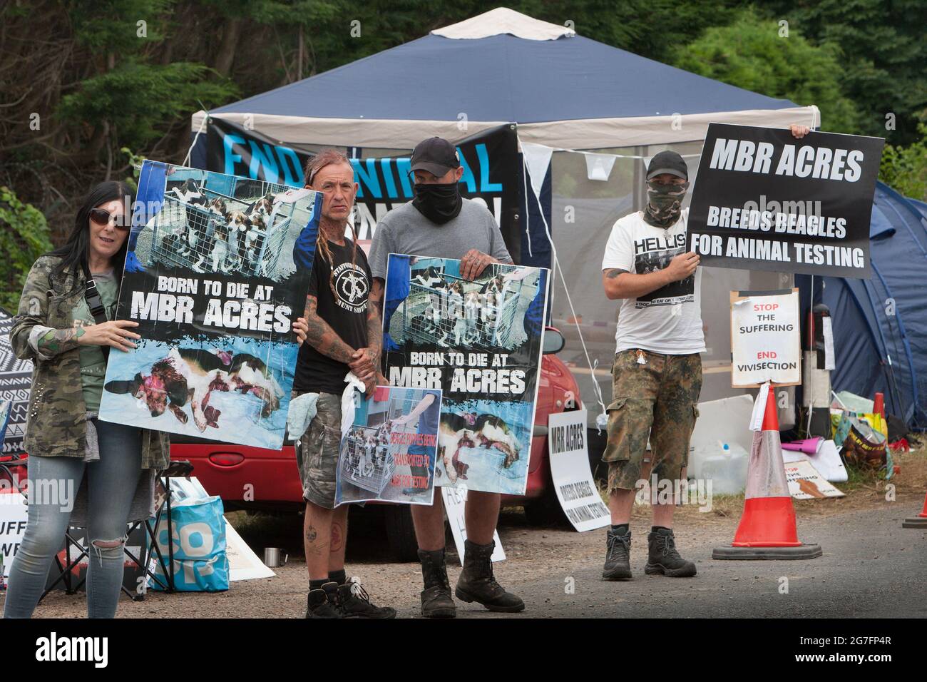 Huntingdon, Royaume-Uni. 13 juillet 2021. Les activistes tiennent des placards pendant la manifestation.les activistes des droits des animaux occupent Camp Beagle, un camp de protestation sur le bord de la route à l'extérieur de beagle éleveur Maréchal bioressources (MBR) Acres. Leurs chiots ont été vendus aux laboratoires d'essais sur animaux. Les militants vont camper à l'extérieur de l'usine jusqu'à ce qu'elle soit fermée et que tous les beagles soient libérés. Crédit : SOPA Images Limited/Alamy Live News Banque D'Images