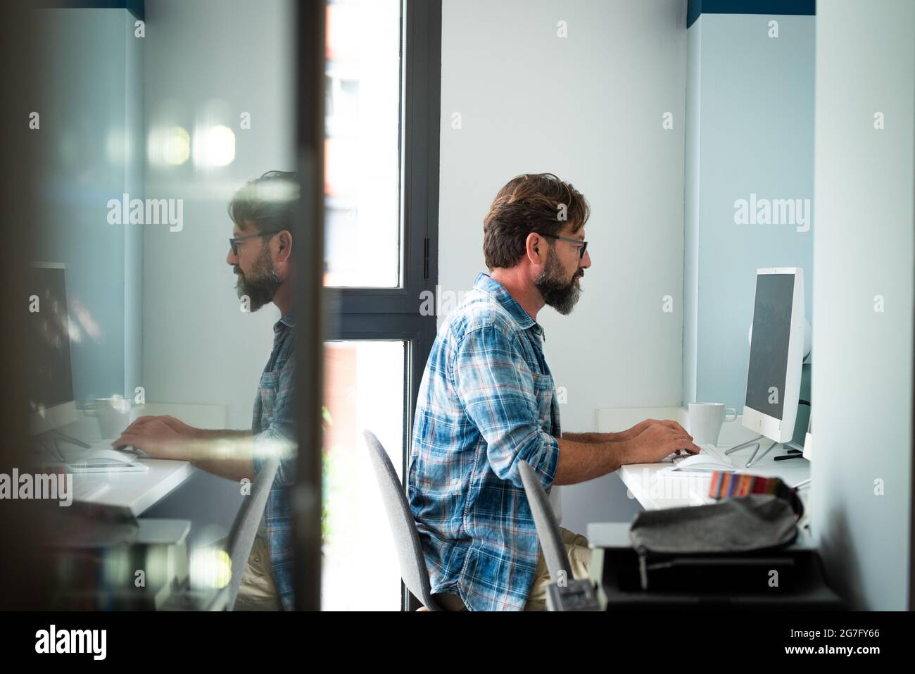 Caucasien freelance personnes homme assis au bureau dactylographiant sur ordinateur de bureau pour le travail en ligne Internet connecté style de vie - hipster adulte homme travaillant Banque D'Images