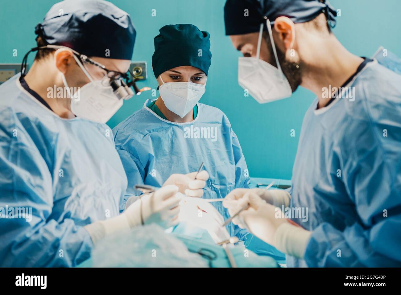 Équipe de médecins opérant le patient dans la salle chirurgicale à l'hôpital - Focus sur l'infirmière femme visage Banque D'Images