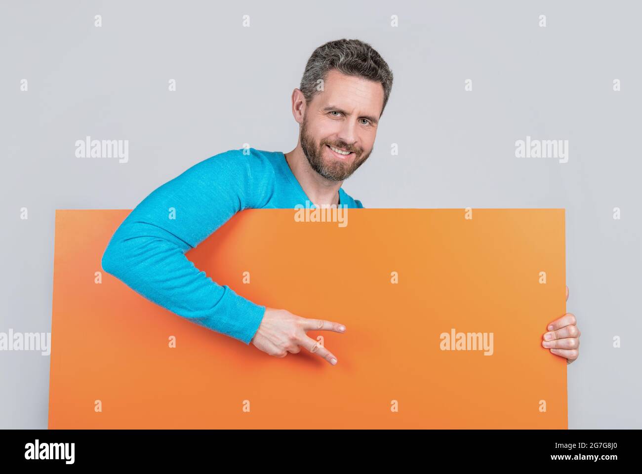 homme derrière une bannière en papier vierge avec un espace pour la copie de la publicité montre la paix geste, annonce. Banque D'Images