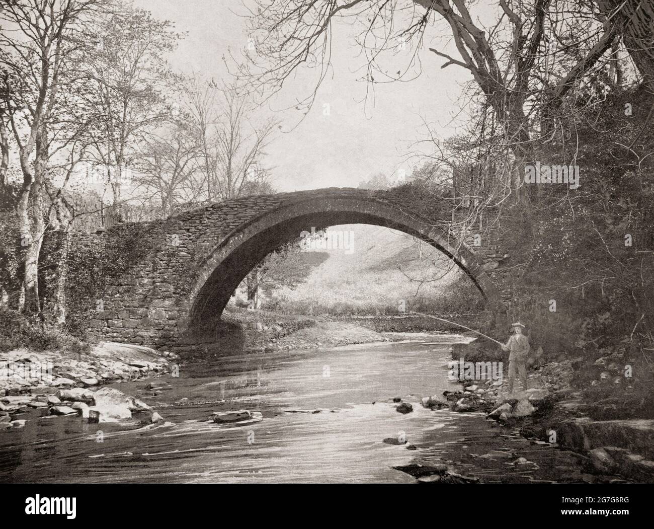 Vue de la fin du XIXe siècle d'un pêcheur sous le pont romain au-dessus de la rivière Mousemill juste à l'ouest de Lanark, une ville dans la ceinture centrale de l'Écosse. Probablement le pont Mousemill, mentionné pour la première fois en 1587. Le pont en pierre qui se tient aujourd'hui semble avoir été construit et remplacé par une structure en bois environ 1649. Au début du XIXe siècle, le pont moderne a été construit à quelques mètres et l'ancien a laissé tomber dans la décomposition. Si probablement d'un héritage romain douteux! Banque D'Images