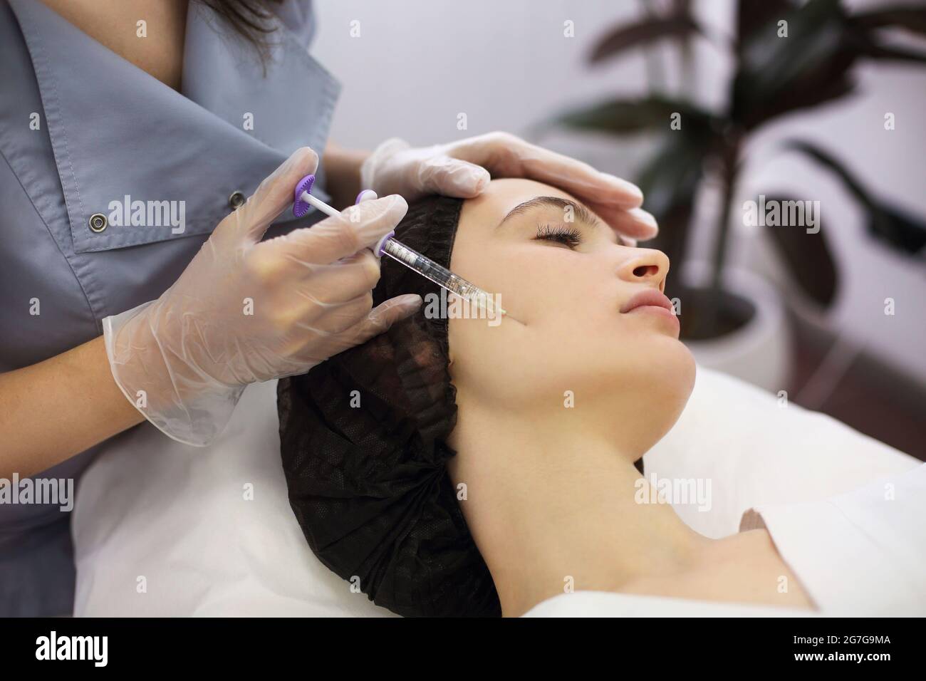 Esthéticienne injectant le visage de la femme au salon de beauté. Gros plan Banque D'Images