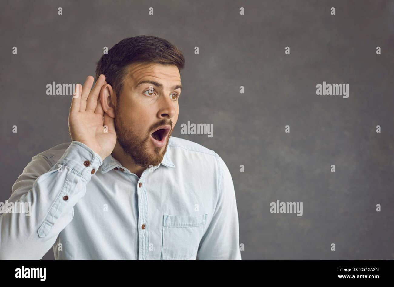 Portrait de l'homme adulte eavesdrop avec le geste auditif écouter les nouvelles de choc Banque D'Images