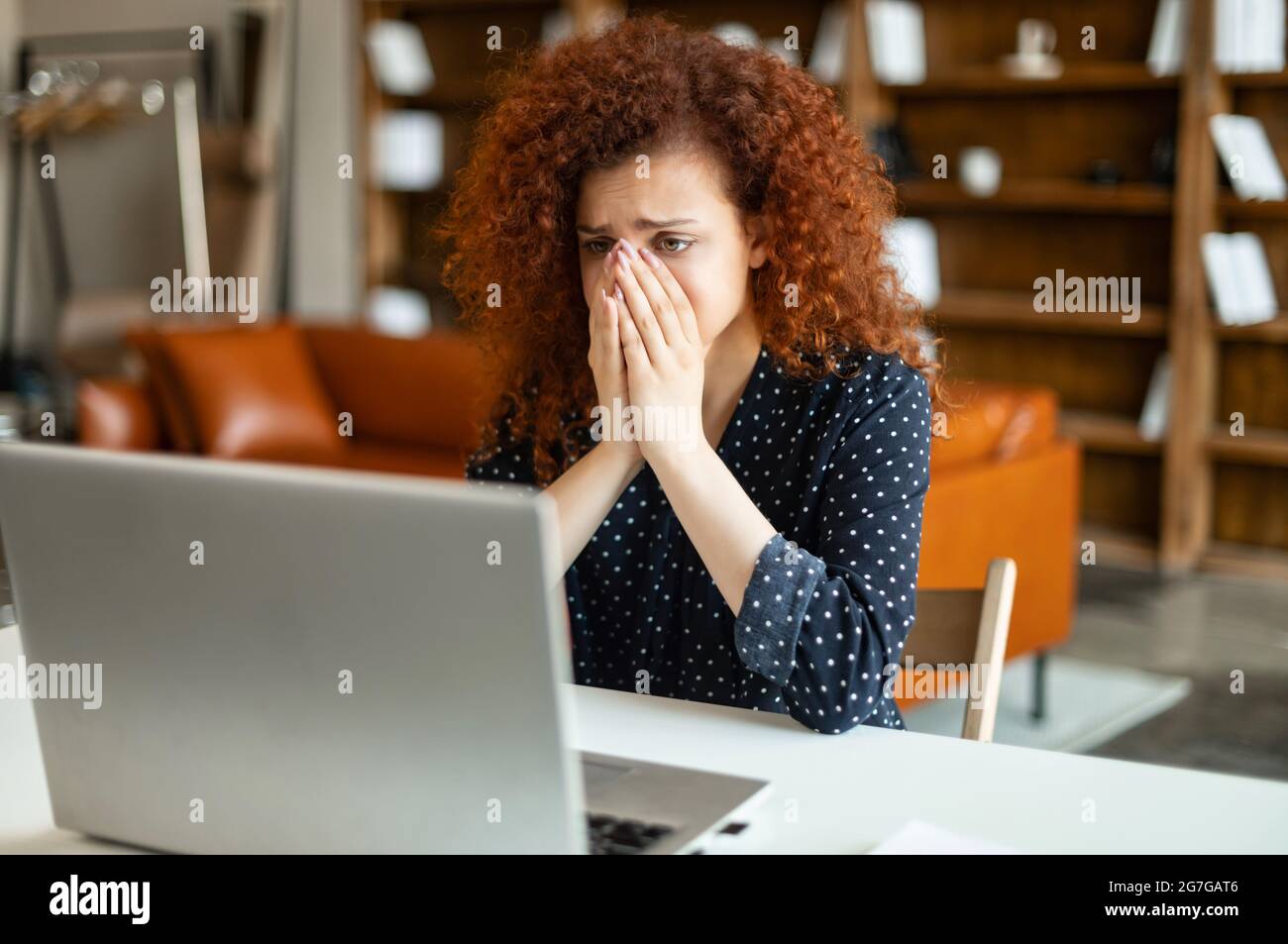 La bataille des délais. Jeune femme de bureau responsable avec une coiffure  mauriquement se sentant fatiguée, épuisée et surtravaillée, femme aux  cheveux rouges assise avec un ordinateur portable ouvert et fermant son