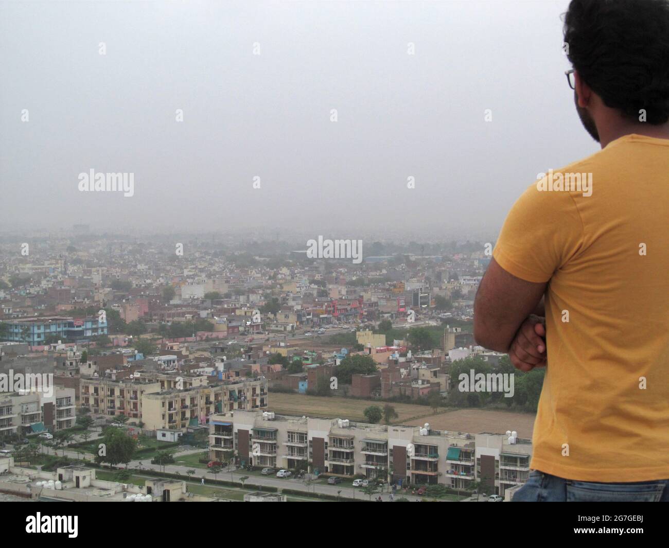 Homme regardant par-dessus City Skyline à Faridabad, Delhi NCR, INDE Banque D'Images