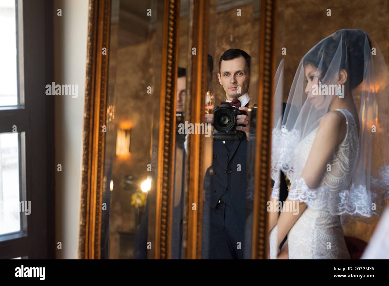 Mariée et mari avec appareil photo prise de vue à travers le miroir Banque D'Images