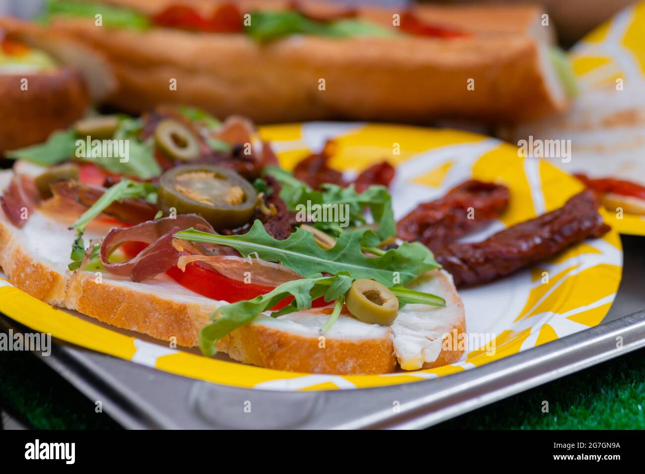 Sandwich à l'arugula, au jambon, au fromage, au jalapeno, aux tomates séchées - gros plan Banque D'Images Sandwich à l'arugula, au jambon, au fromage, au jalapeno, aux tomates séchées - gros plan Banque D'Images