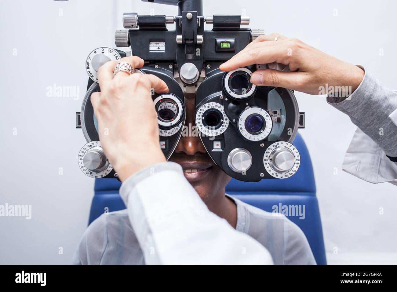 Optométriste ajustant l'équipement d'optométrie pendant l'étude de la vue d'une femme noire Banque D'Images