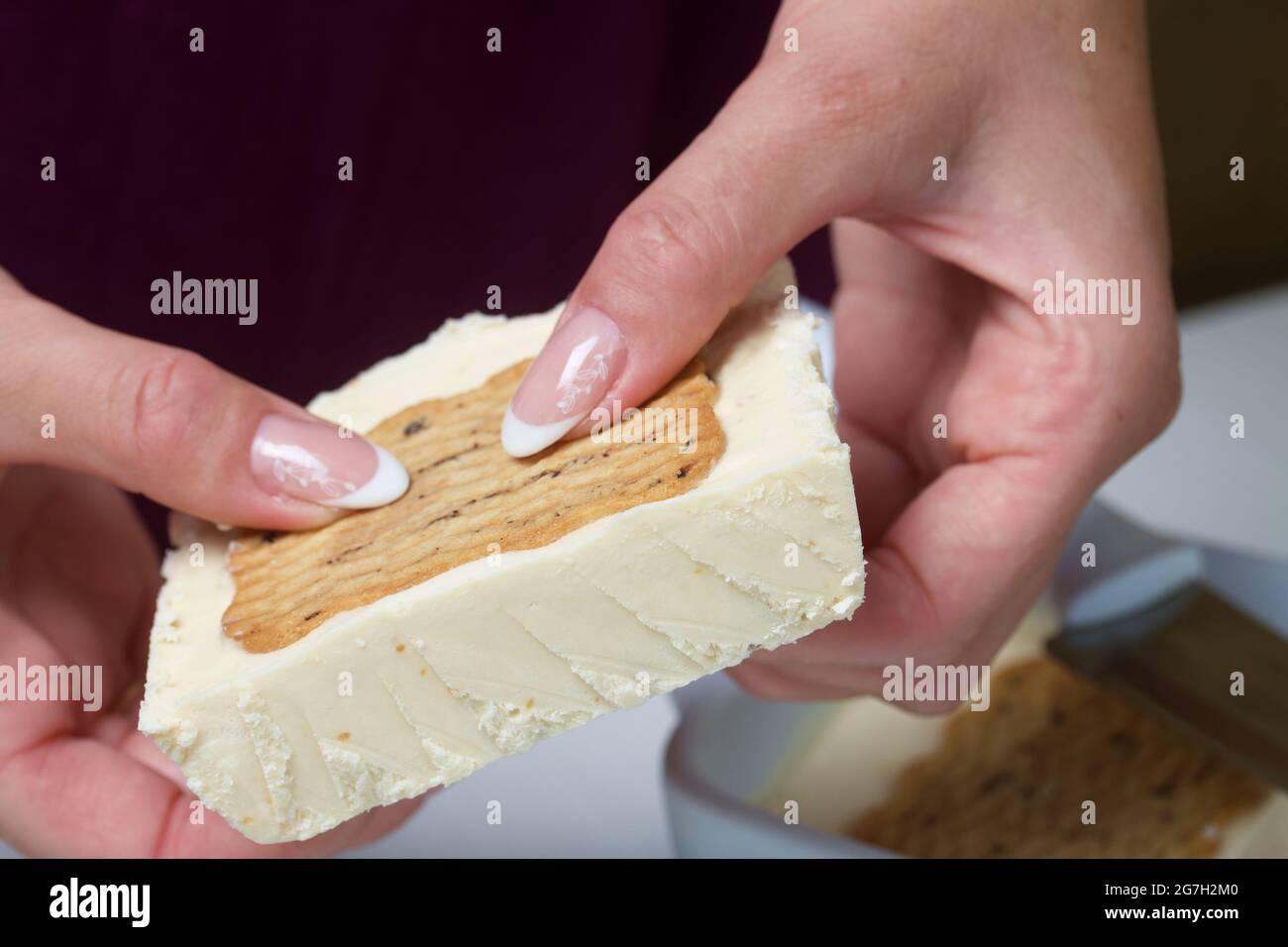 Une femme coupe de la glace maison. Biscuits et crème. Gros plan. Banque D'Images