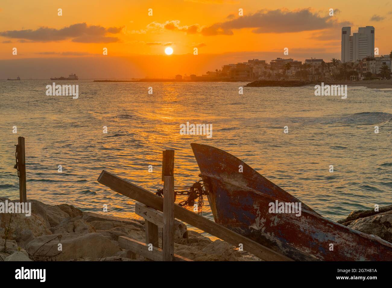 Vue au lever du soleil sur la plage de Carmel, en direction de Bat Galim, avec de petits bateaux. Haïfa, nord d'Israël Banque D'Images