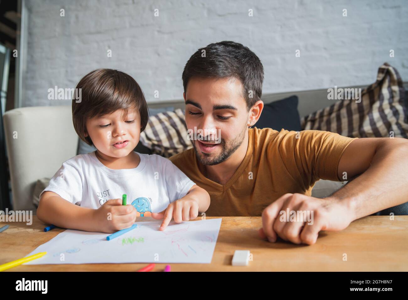Père et fils jouant ensemble à la maison. Banque D'Images