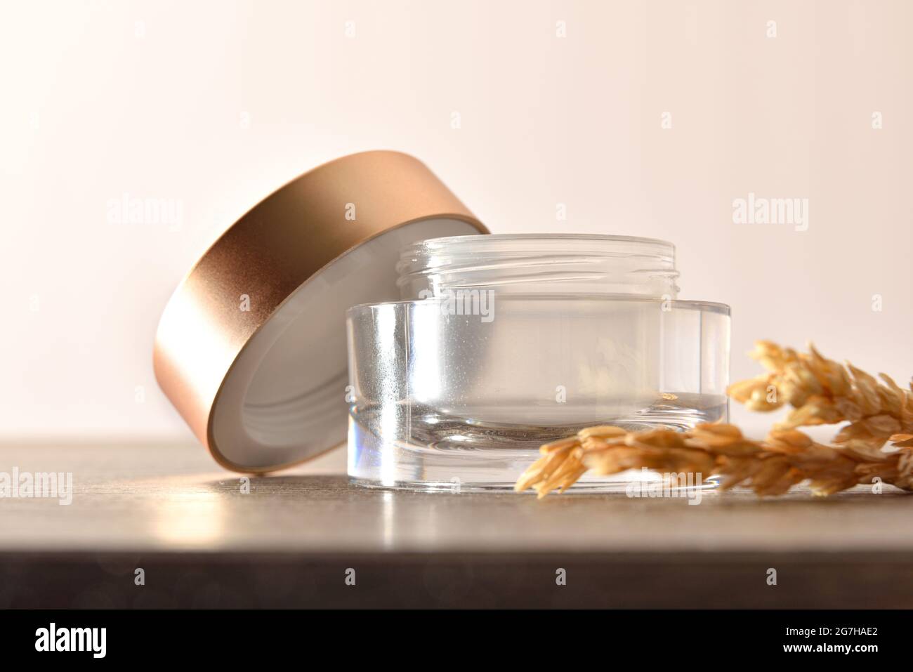 Pot en verre ouvert pour le visage ou le corps de crème vide avec couvercle  doré sur table en bois et pointes d'avoine avec fond beige isolé Photo  Stock - Alamy