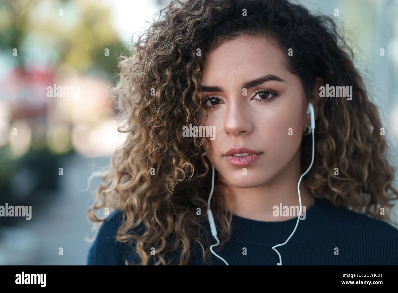 Jeune femme latine portant des écouteurs à l'extérieur. Banque D'Images