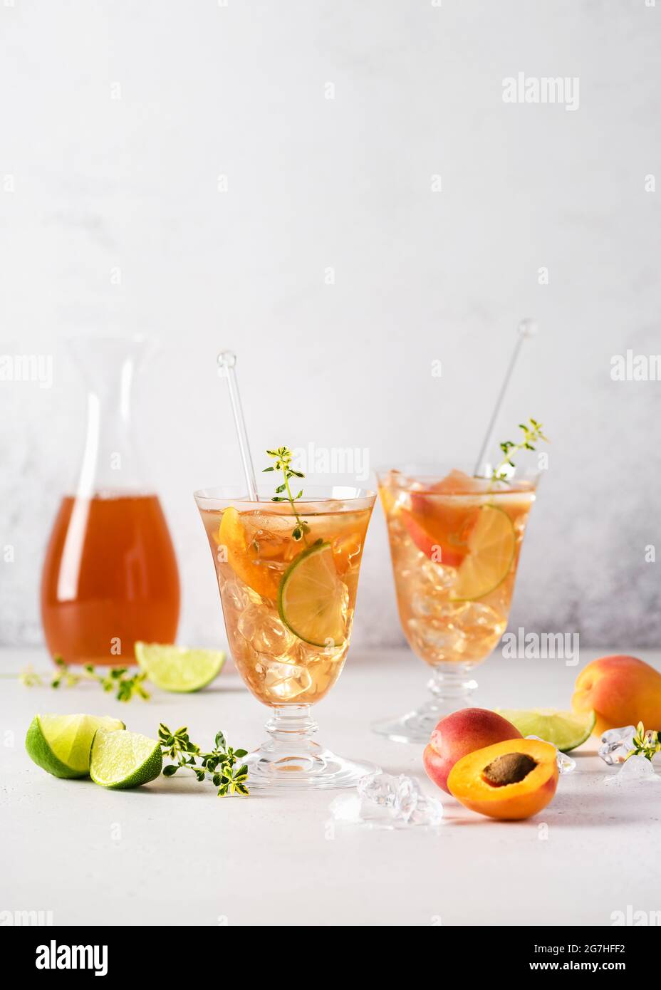 Cocktail d'abricot frais avec glace, citron vert et thym citron en verre. Cocktails rafraîchissants faits maison sans alcool en été. Mise au point sélective. Copier l'espace. Banque D'Images