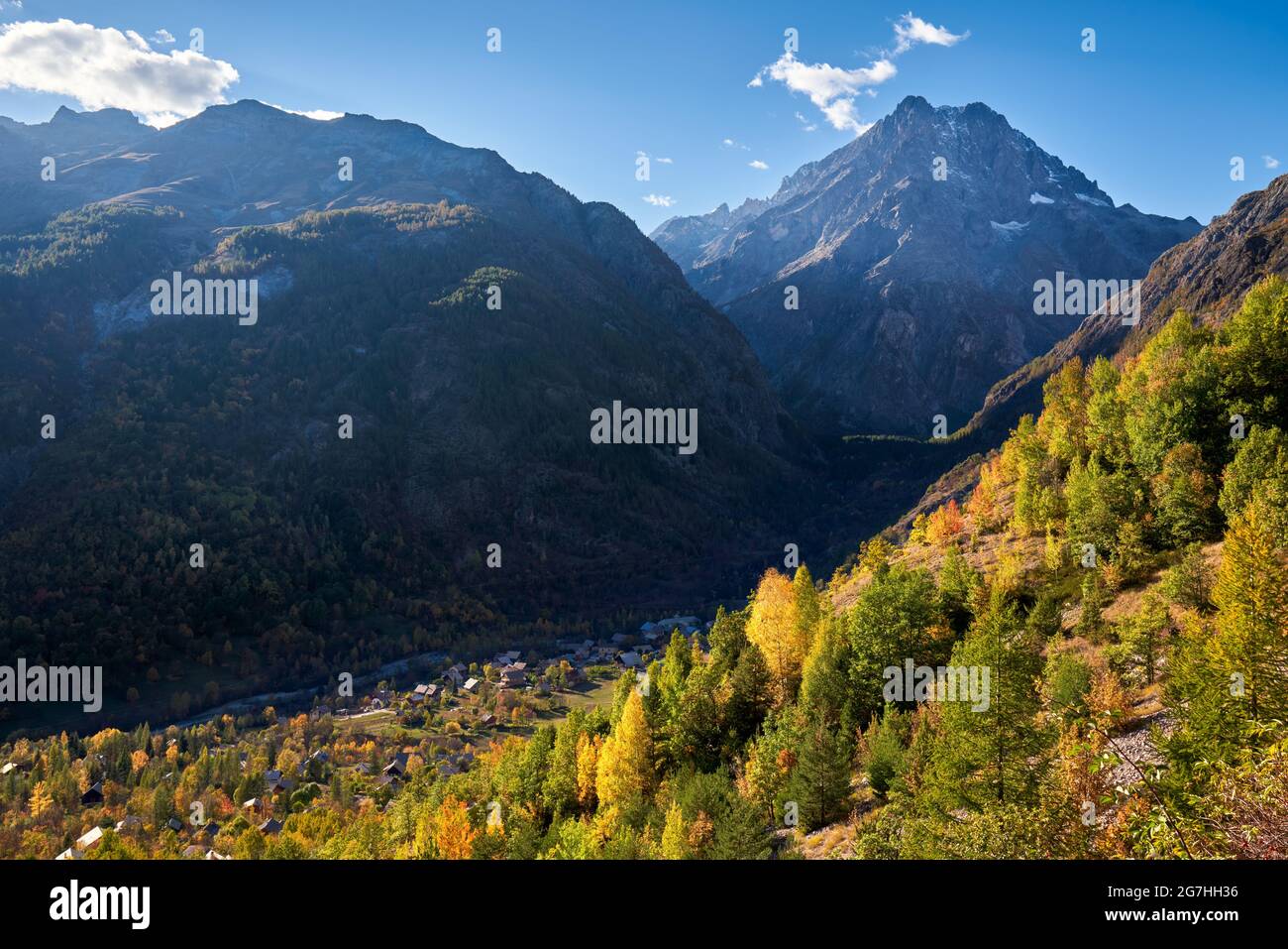 Le village des Claux dans la vallée de Vallouise avec le Mont Pelvoux (Parc National des Ecrins) au loin en automne. Hautes-Alpes, Alpes françaises, France Banque D'Images