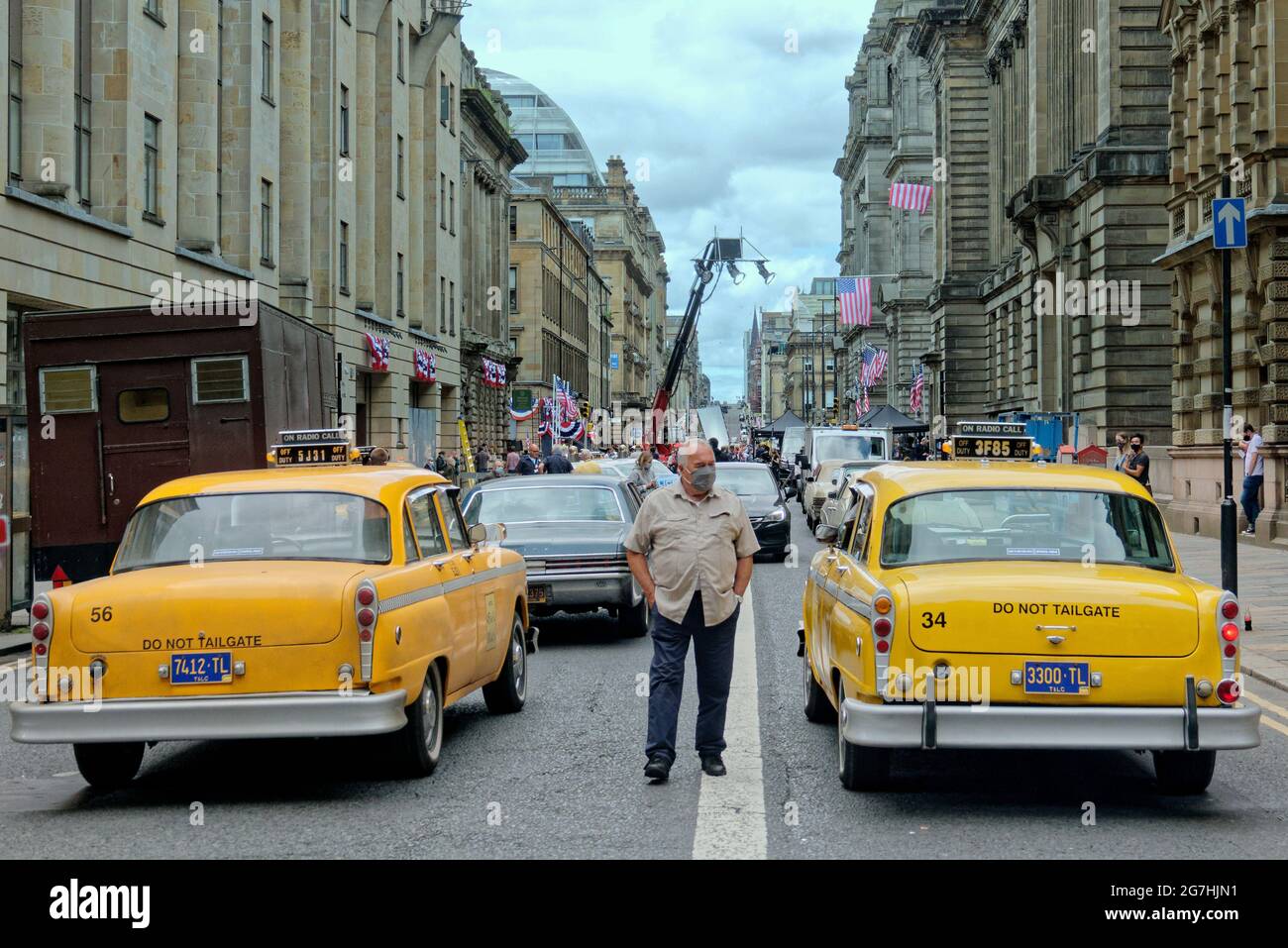 Glasgow, Écosse, Royaume-Uni, 14 juillet 2021. Le tournage de l'Indiana jones a commencé aujourd'hui, les restrictions de circulation commençant dans le centre-ville et les façades des magasins et les décorations sont finies alors que les locaux attendaient l'arrivée de harrisson ford laura de la télévision écossaise filmée sur le plateau de son no show. Une scène d'accident a été filmée sous l'arche de la rue john avec une bannière accueillant les astronautes à la maison tandis que les habitants peinaient à voir sous un set bien garé, une équipe d'ambulance a assisté à la scène avec un moteur d'incendie comme un journaliste a interviewé des témoins. Crédit Gerard Ferry/Alay Live News Banque D'Images