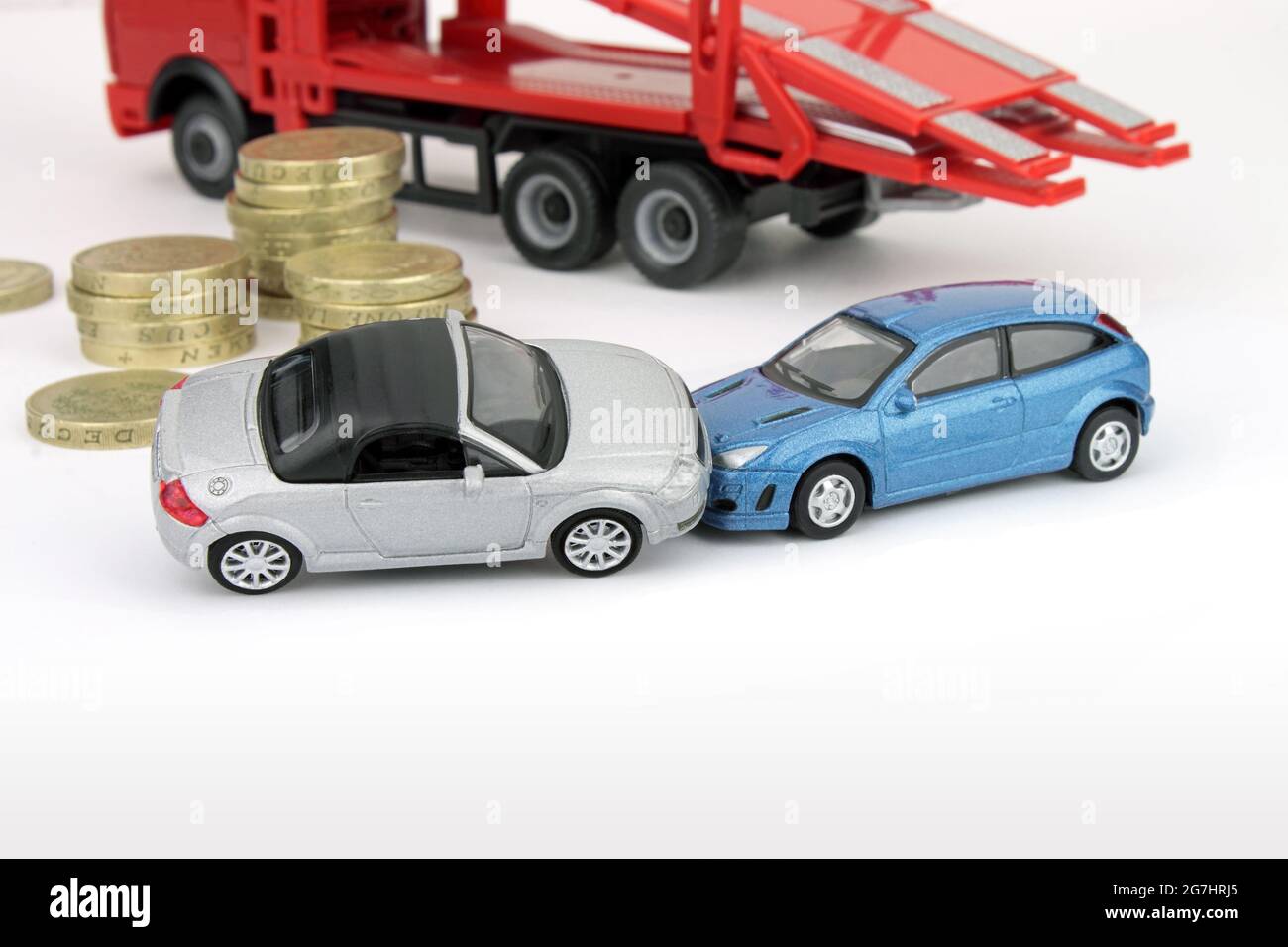 Un accident de voiture impliquant deux voitures, avec des pièces de monnaie et un camion de panne sur fond blanc. Banque D'Images