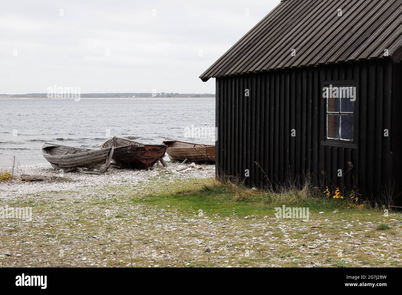 Ancien hangar et bateaux à la station de pêche historique de Helgumannen située sur l'île de Faro dans la province suédoise de Gotland. Banque D'Images