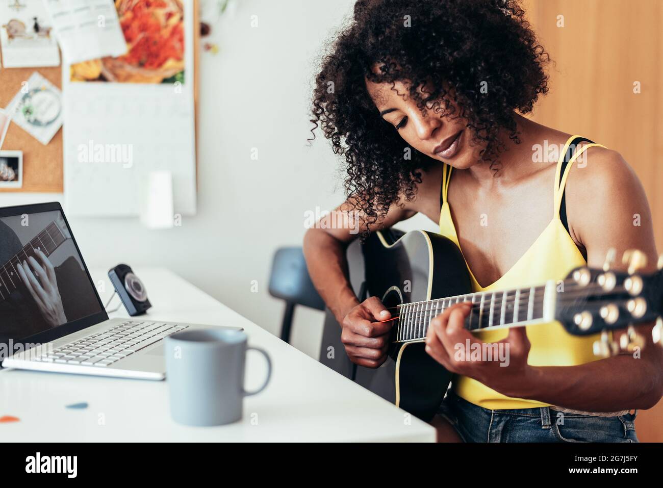 femme africaine apprenant à jouer de la guitare devant un ordinateur  portable. Concept d'apprentissage virtuel Photo Stock - Alamy