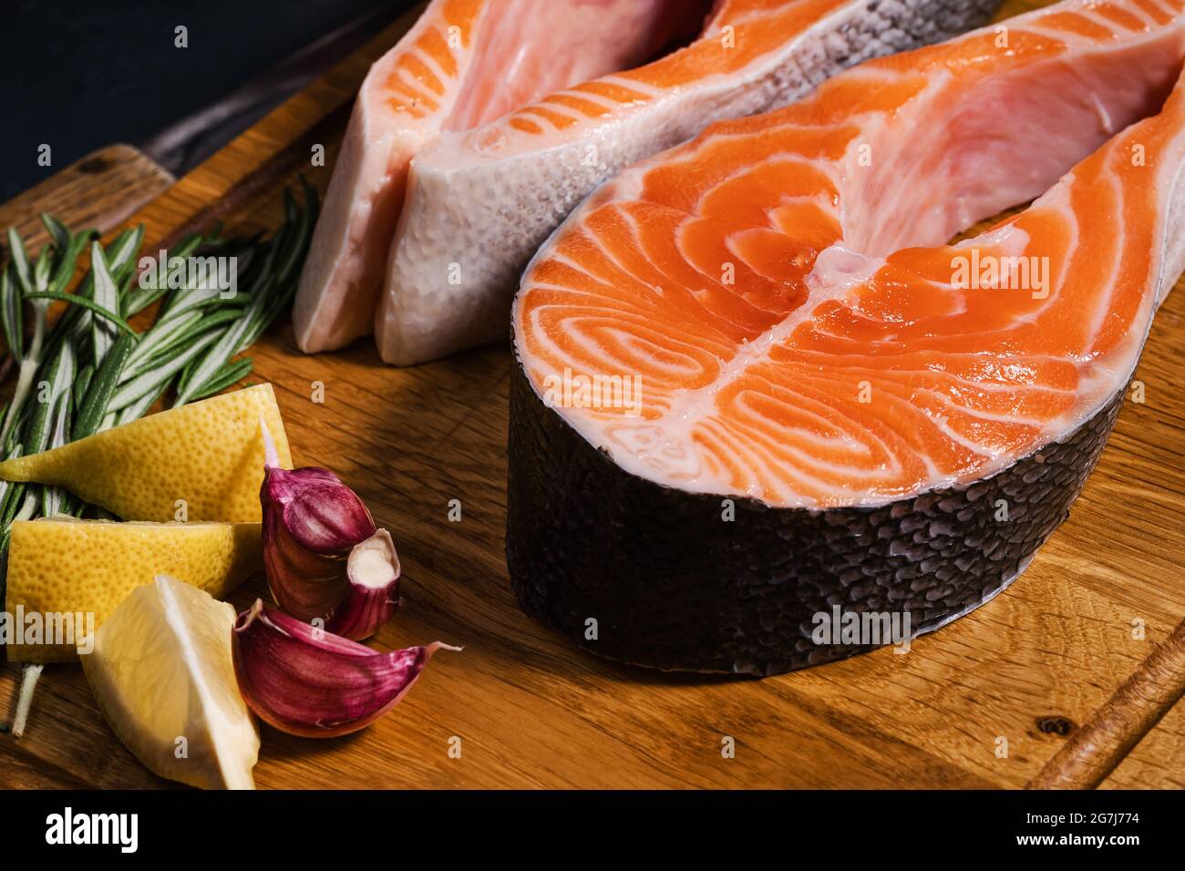 Steaks de saumon. Tranches de saumon frais avec épices, herbes et citron sur planche à découper en bois, vue du dessus Banque D'Images