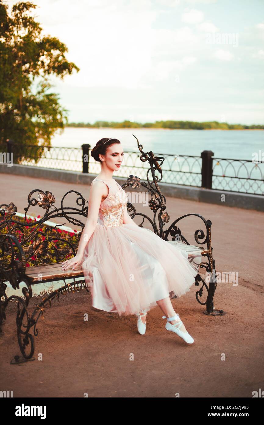 une jeune femme élégante en robe princesse est assise dans une robe rose  sur un banc sur la rive de la rivière, un mariage romantique ou une date  Photo Stock - Alamy