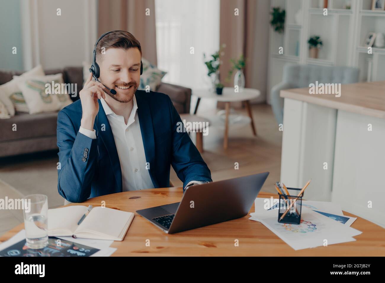 Professionnel satisfait barbu homme entrepreneur montres formation entreprise webinar en ligne porte casque looksat ordinateur portable a un travail d'ordinateur distant Banque D'Images