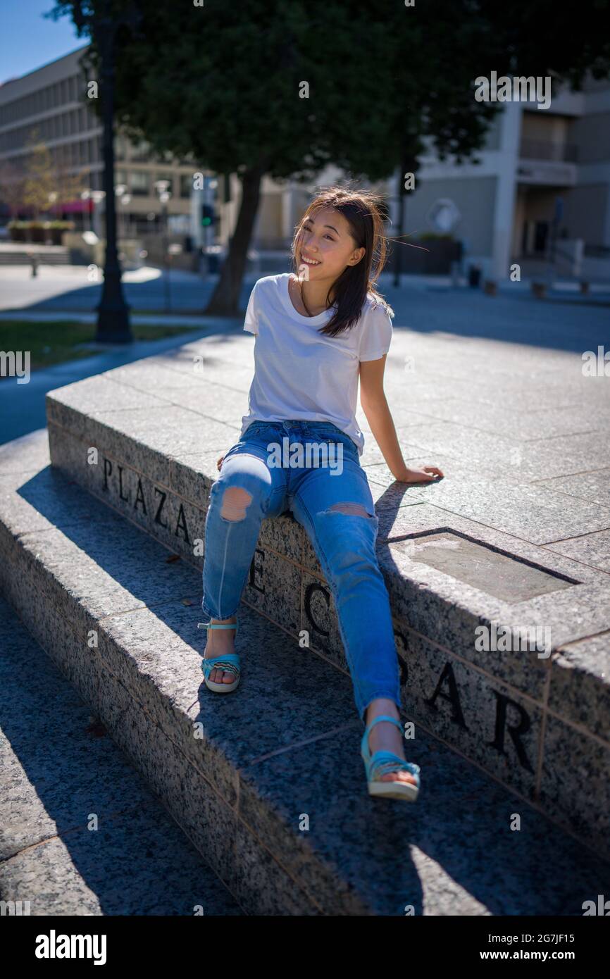 Jeune femme asiatique assise sur les marches du centre-ville Plaza Banque D'Images