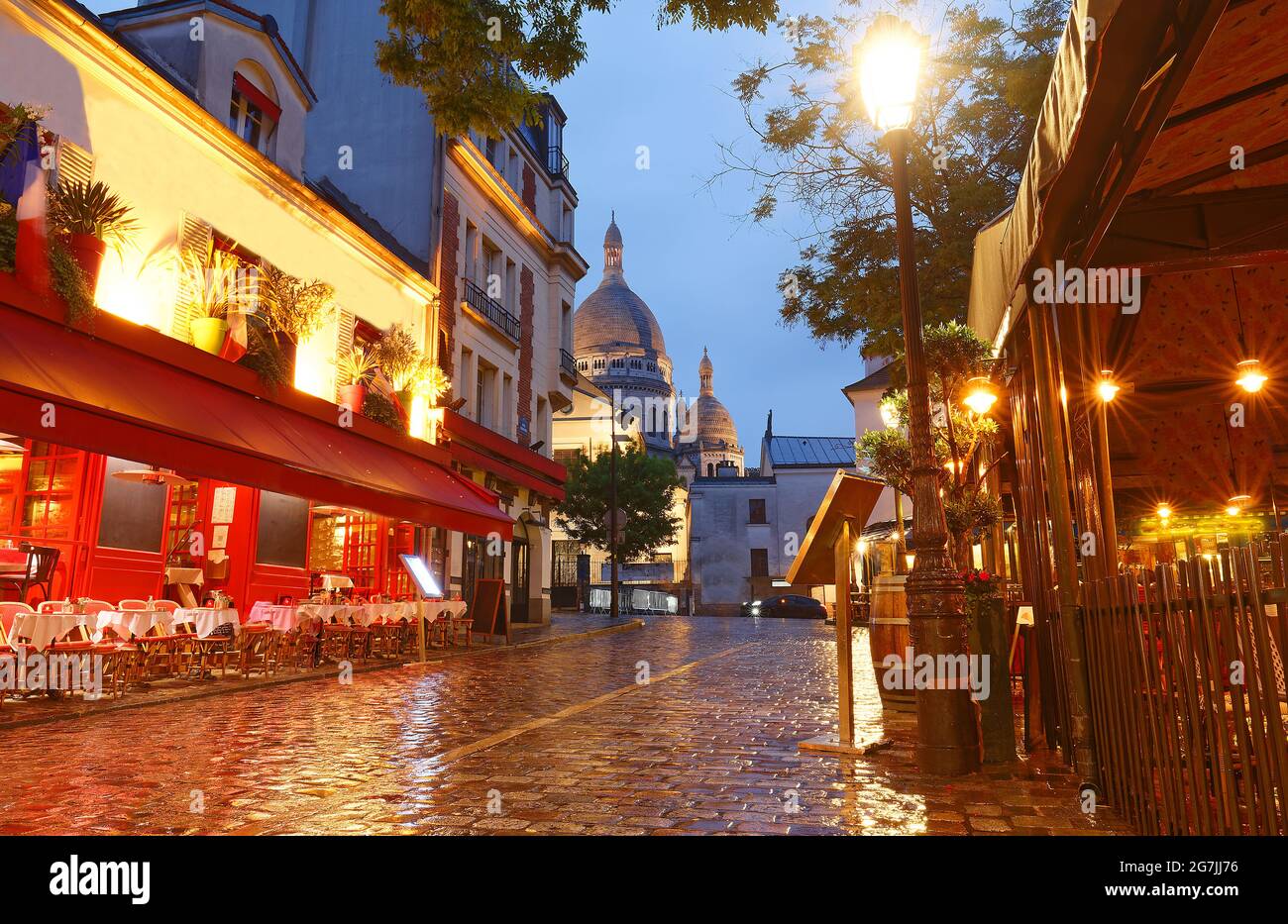 La place du Tertre avec des tables de café et le Sacré-coeur dans la nuit des pluies , quartier Montmartre à Paris, France Banque D'Images