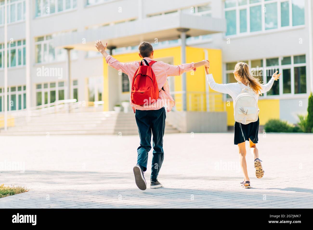 Écoliers en uniforme garçon et fille qui vont à l'école avec des sacs à dos d'école, les élèves sur le chemin de l'école, étudiant pour les enfants Banque D'Images