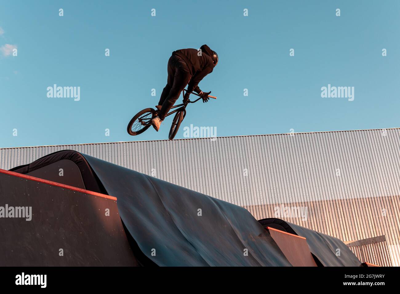 BMX rider faire le tour sur la rampe dans le parc de skate. Sports, sports extrêmes, freestyle, le concept de l'activité en plein air. Banque D'Images
