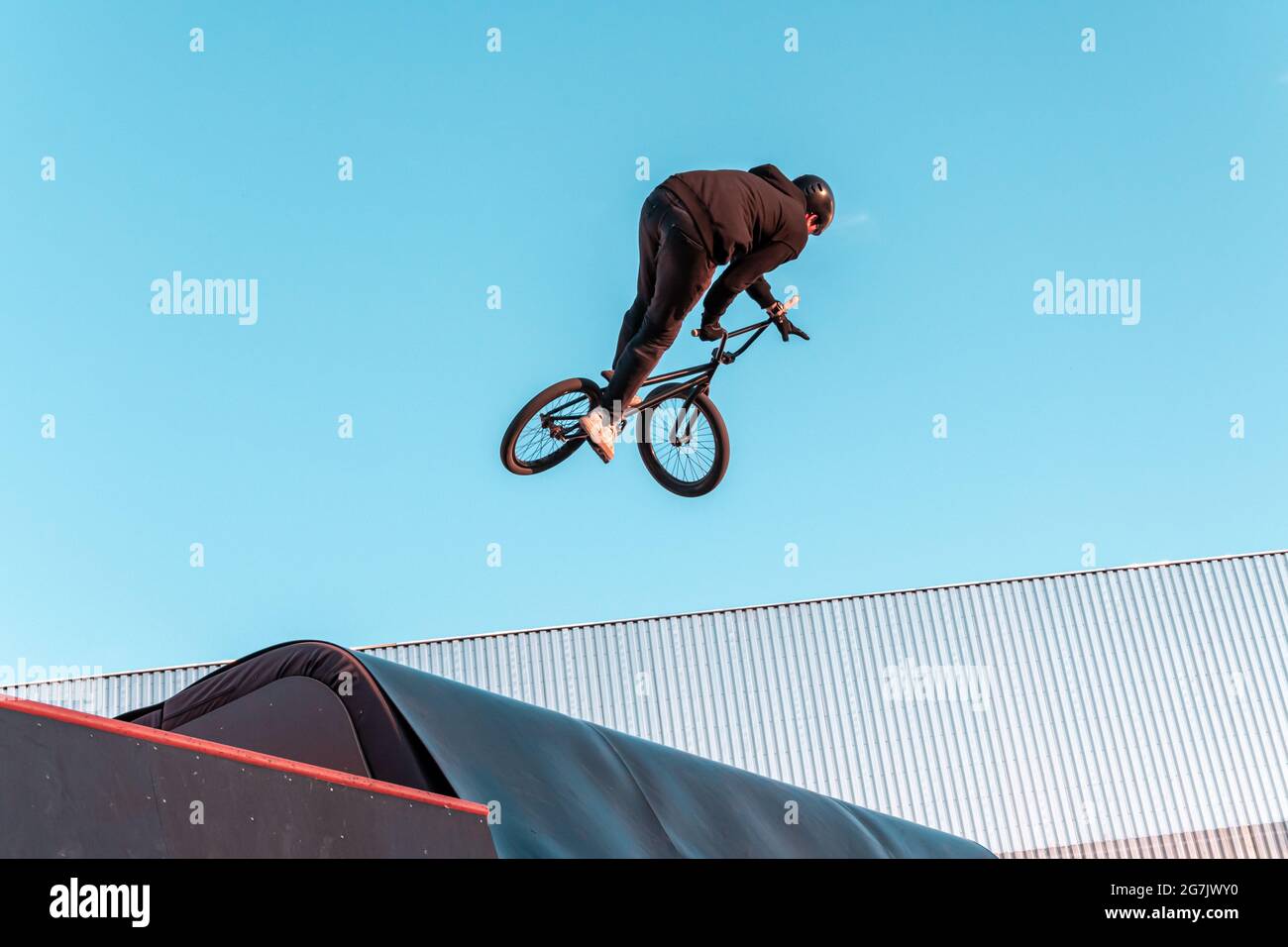 BMX rider faire le tour sur la rampe dans le parc de skate. Sports, sports extrêmes, freestyle, le concept de l'activité en plein air. Banque D'Images