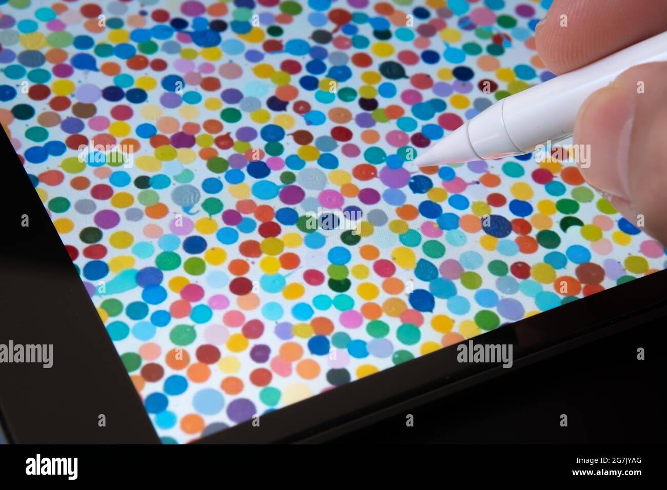 Le stylet pointe sur une peinture de spot unique visible sur un iPad flou. L'art numérique de Damien Hirst qui s'est vendu sous le nom de devise NFT. Stafford, Royaume-Uni, juillet Banque D'Images