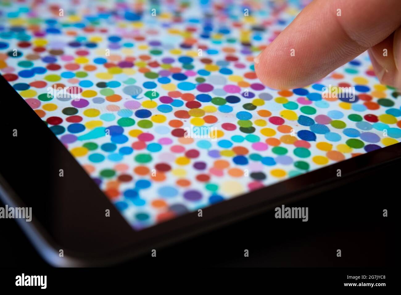 Toucher le doigt peinture de spot unique vue sur iPad flou. L'art numérique de Damien Hirst qui s'est vendu sous le nom de devise NFT. Stafford, Royaume-Uni, juillet 14, Banque D'Images