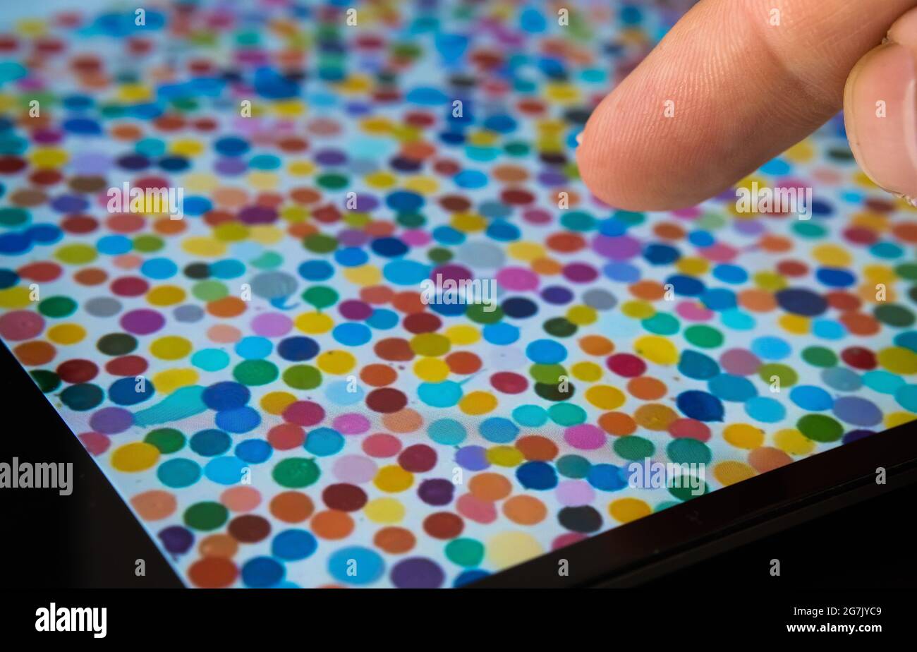 Toucher le doigt peinture de spot unique vue sur iPad flou. L'art numérique de Damien Hirst qui s'est vendu sous le nom de devise NFT. Stafford, Royaume-Uni, juillet 14, Banque D'Images