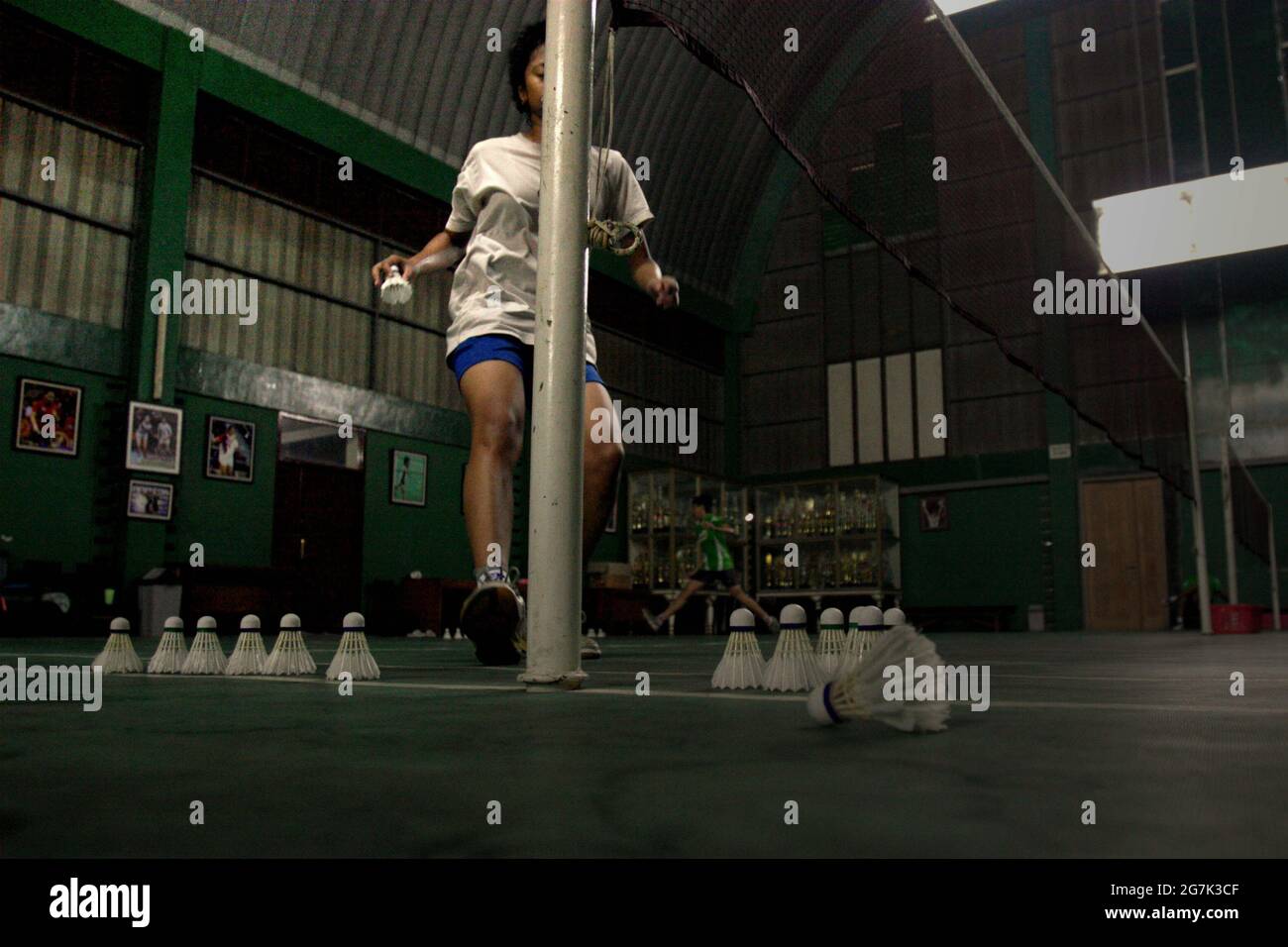 Les jeunes joueurs de badminton ont une session d'entraînement au club de badminton Jaya Raya à Jakarta, en Indonésie, photographié dans un fond d'armoire à trophées et une photo de l'ancien joueur vedette du club, Susi Susanti, médaillé d'or olympique. Banque D'Images